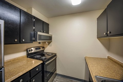 a kitchen with a stove top oven next to a microwave at Broadmoor Springs, Colorado Springs, CO, 80906